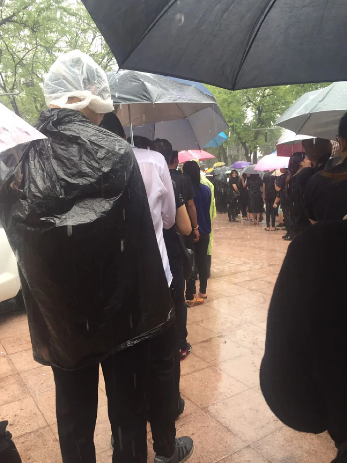 สายฝนจะแรงแค่ไหน ใจไม่หวั่น...ประชาชนนับพัน เข้าแถวรอลงนามถวายความอาลัยท่ามกลางสายฝนที่กระหน่ำตกอย่างหนัก