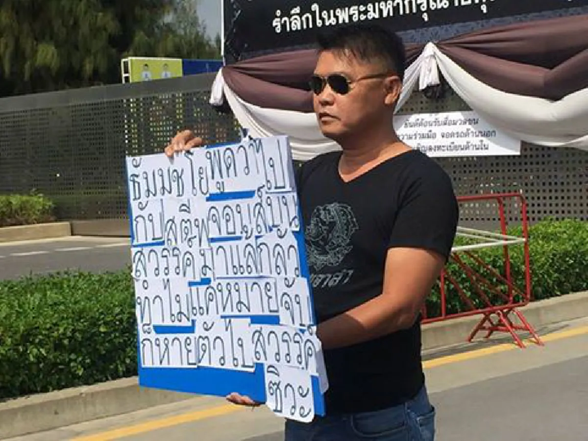 นายแน่มาก!! หนุ่มใหญ่ถือป้ายหน้าวัดธรรมกายไล่ธัมมชโยไปมอบตัว ลั่นปีใหม่ตร.จะได้ไปอยู่กับลูกเมีย
