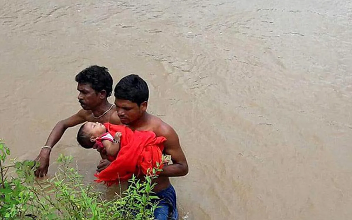 หัวอกพ่อ!! ชายอินเดียอุ้มลูกป่วยชูเหนือหัว เดินฝ่าน้ำท่วมสูงเกือบ 2 เมตร เพื่อพาลูกไปโรงพยาบาล