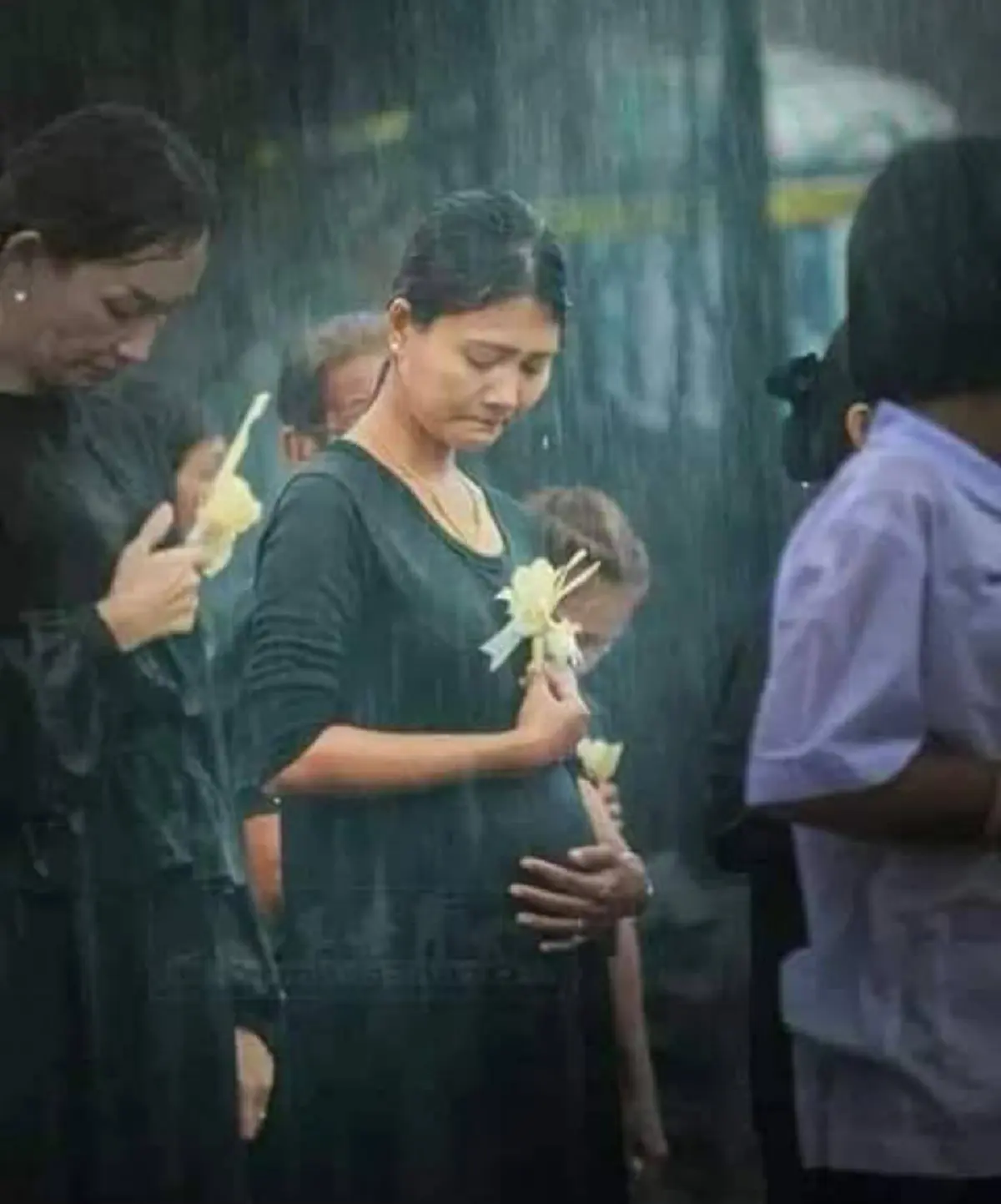 หญิงท้องแก่ต่อแถวถวายดอกไม้จันทน์ กลางสายฝน 