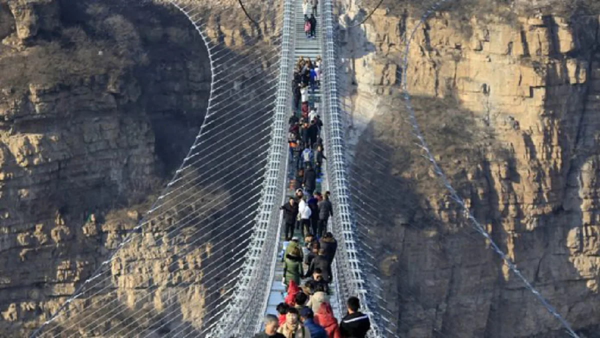 ขอเชิญผู้กล้า!! จีนทุบสถิติสร้างสะพานพื้นกระจกเชื่อมหน้าผายาวที่สุดในโลก สูงเท่าตึก 66 ชั้น แถมเพิ่มลูกเล่นแกว่งไปมาเพื่อความเร้าใจ