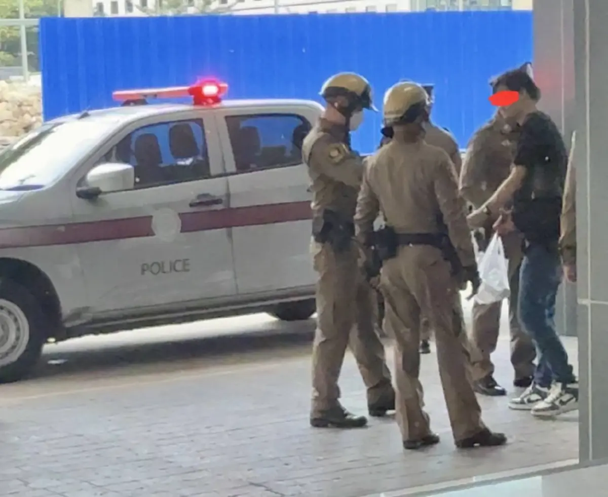  นายหำ ถือถุงใส่ข้าวกล่อง และ น้ำที่ หญิง ผสห. สงสารไปซื้อมาให้ทาน ระหว่างรอตำรวจท้องที่มารับตัวไปดำเนินคดี 