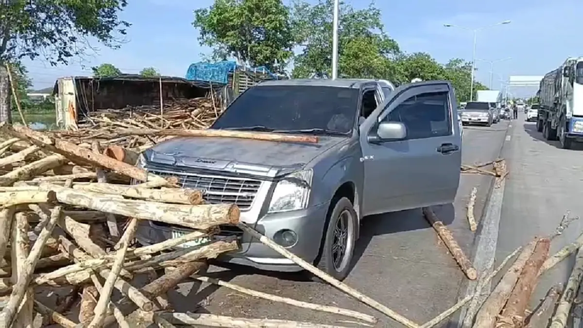 ระทึกแยกไฟแดงสุพรรณฯ รถพ่วงบรรทุกไม้ยูคาพลิกคว่ำ กระเด็นใส่รถ