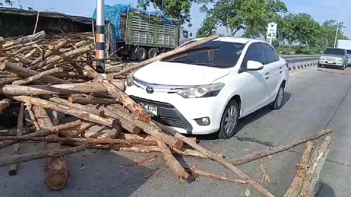 ระทึกแยกไฟแดงสุพรรณฯ รถพ่วงบรรทุกไม้ยูคาพลิกคว่ำ กระเด็นใส่รถ